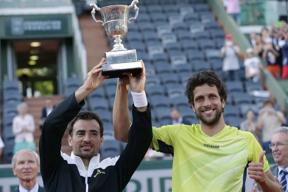 Brazil’s Marcelo Melo (R) and Croatia’s Ivan Dodig celebrate with the trophy following their victory over US Bob and Mike Bryan celebrate at the end of the men’s double final match of the Roland Garros 2015 French Tennis Open in Paris on June 6, 2015. AFP PHOTO / KENZO TRIBOUILLARD