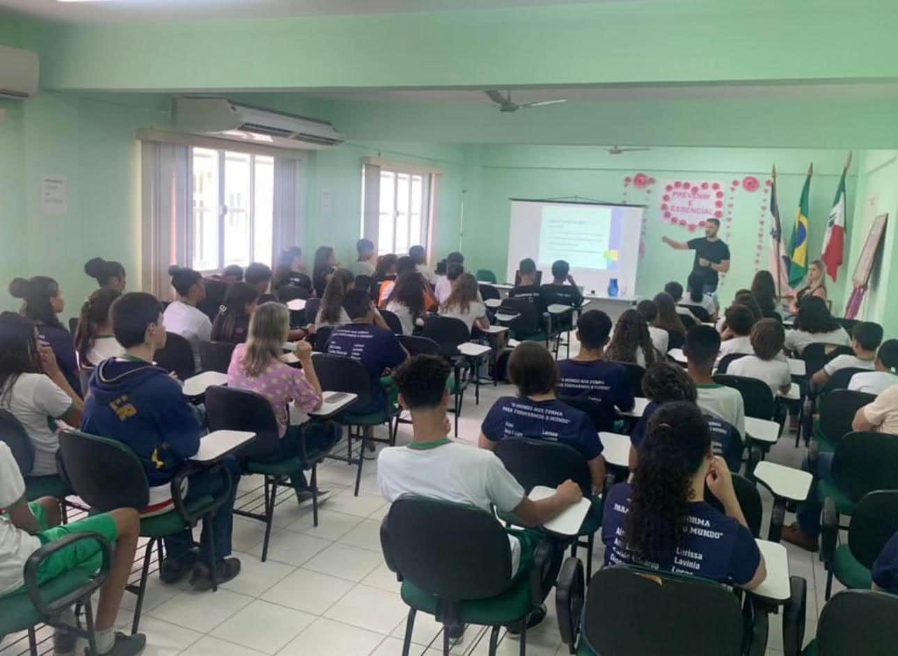 Foto de uma sala de aula com vários alunos sentados na carteira