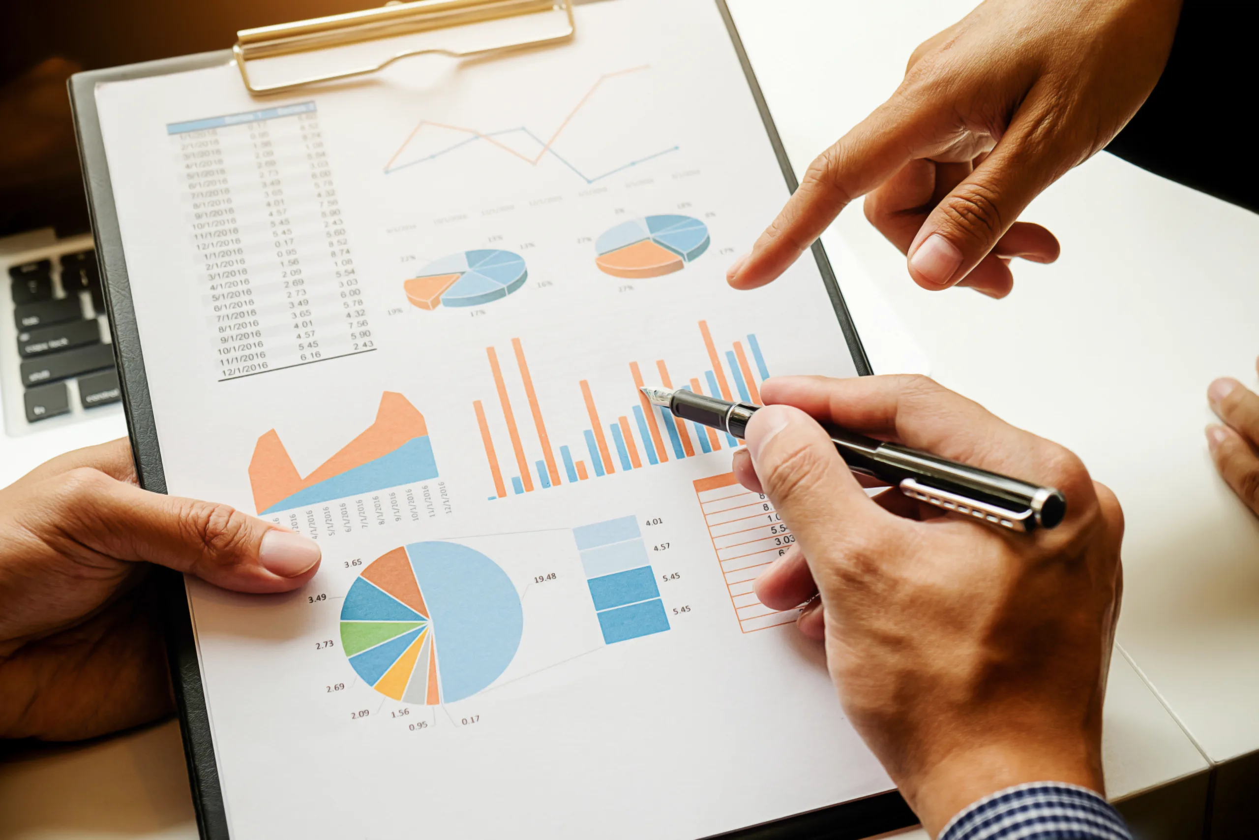 Business concept. Business people discussing the charts and graphs showing the results of their successful teamwork. Selective focus.