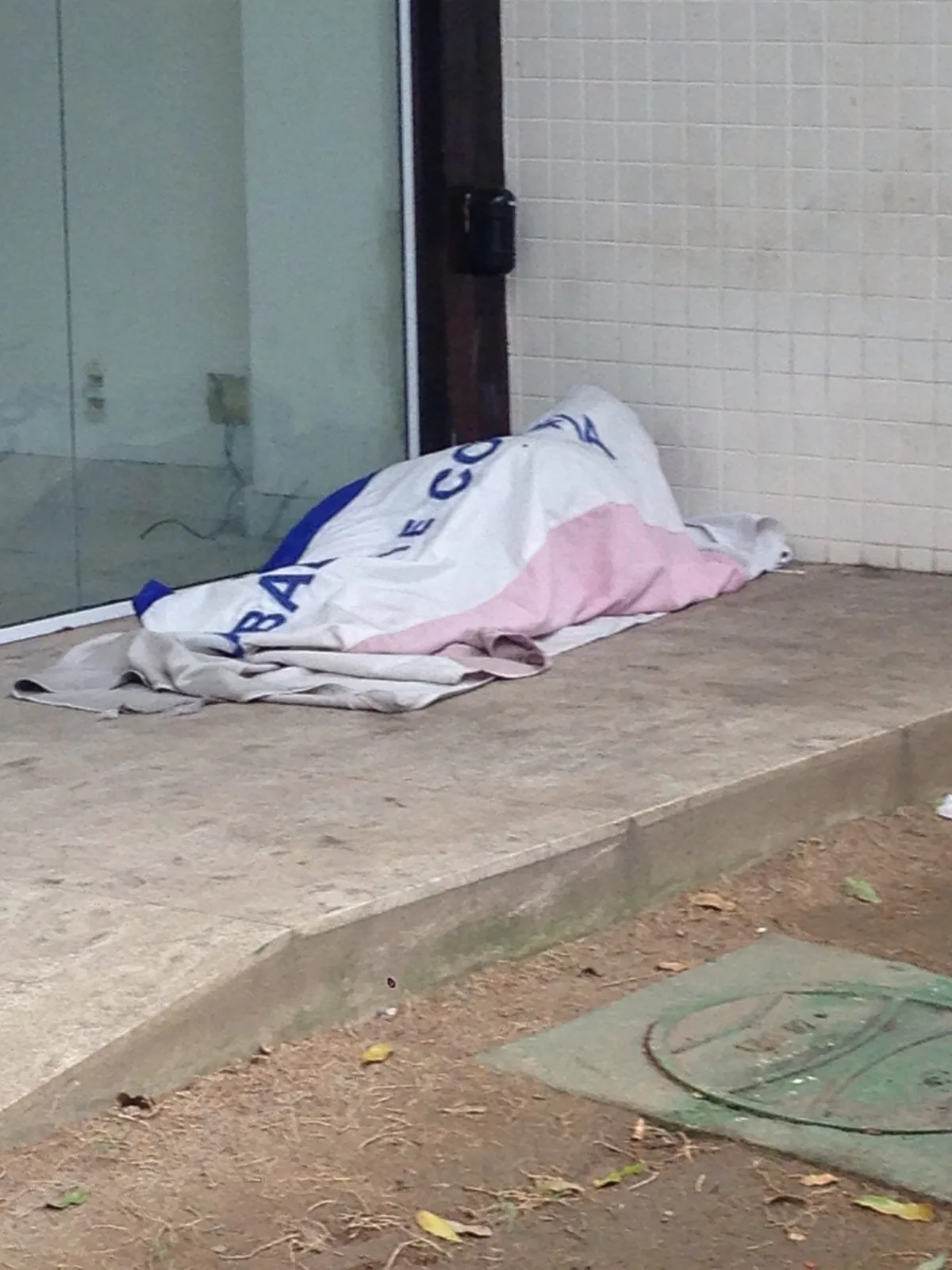 Bandeira do Estado é usada como cobertor de morador de rua na Praia do Canto