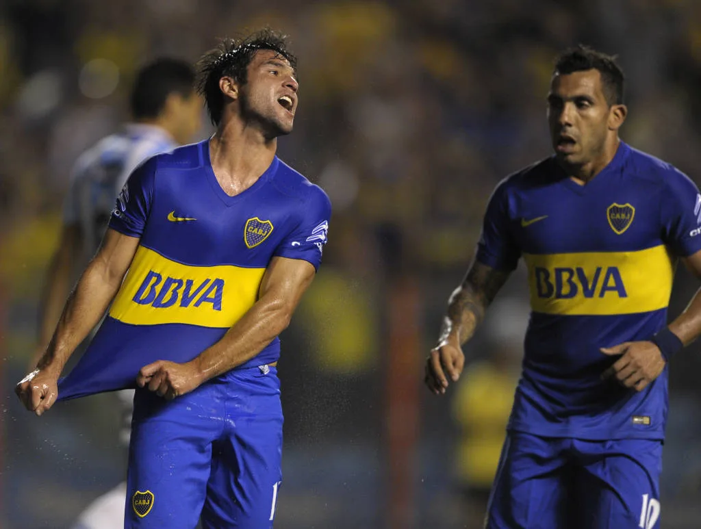 Boca Juniors’ midfielder Nicolas Lodeiro (L) celebrates with teammate forward Carlos Tevez after scoring the team’s third goal against Atletico Rafaela during their Argentina First Division football match at La Bombonera stadium, in Buenos Aires, Argentina, on April 2, 2016. AFP PHOTO / ALEJANDRO PAGNI / AFP PHOTO / ALEJANDRO PAGNI