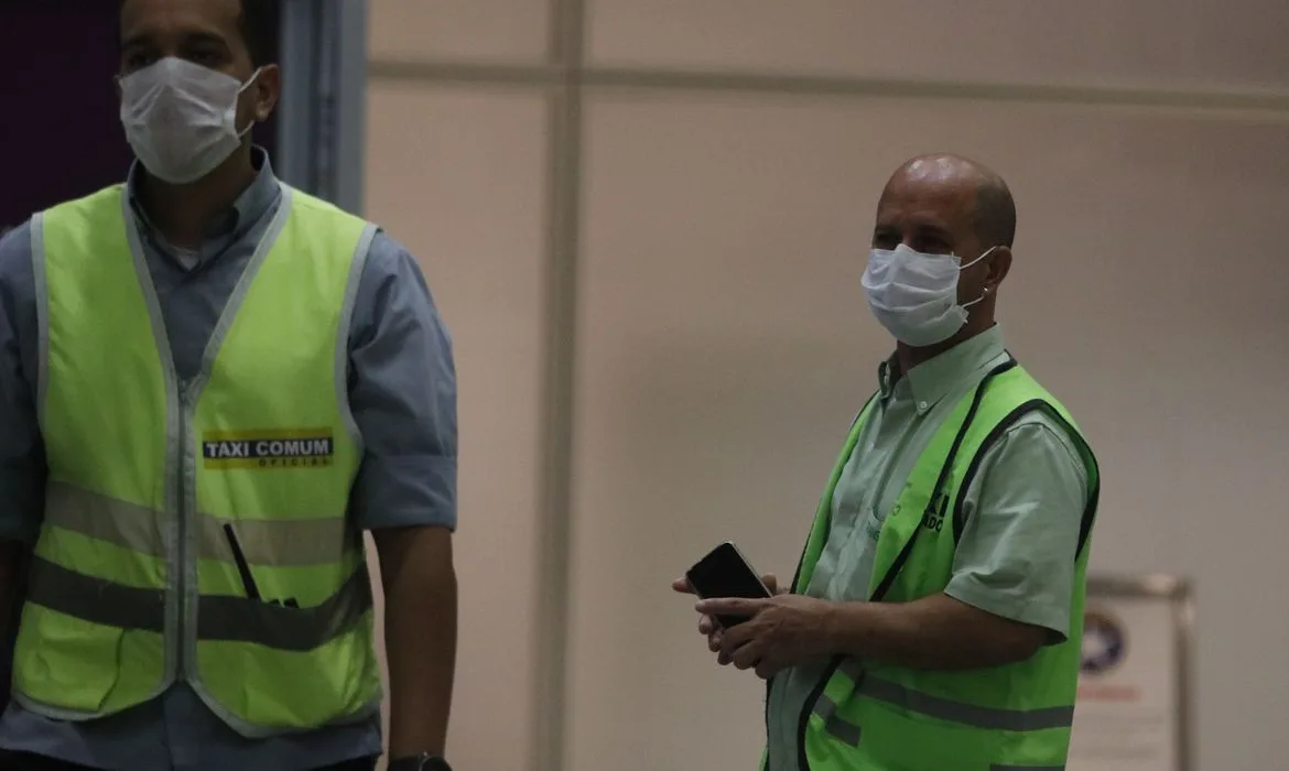 Passageiros e funcionários circulam vestindo máscaras contra o novo coronavírus (Covid-19) no Aeroporto Internacional Tom Jobim- Rio Galeão