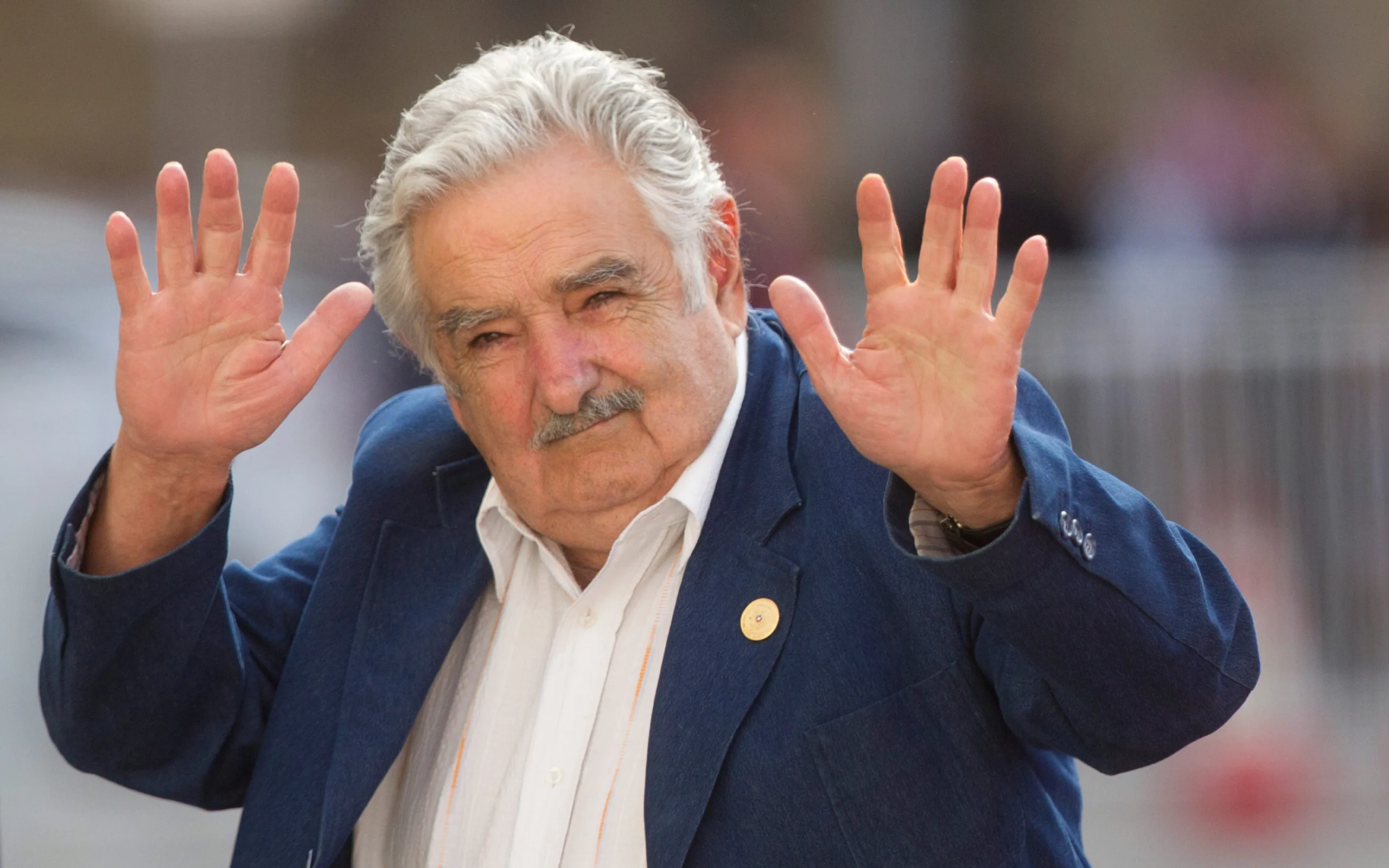 Uruguay’s president Jose Mujica waves at the press upon his arrival at La Moneda presidential palace in Santiago, on March 10, 2014.