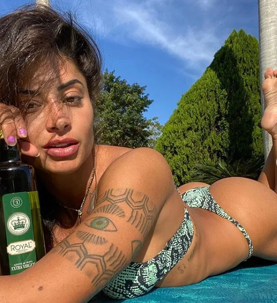 Segurando um azeite, Aline Riscado ensina mulheres como sensualizar nas fotos