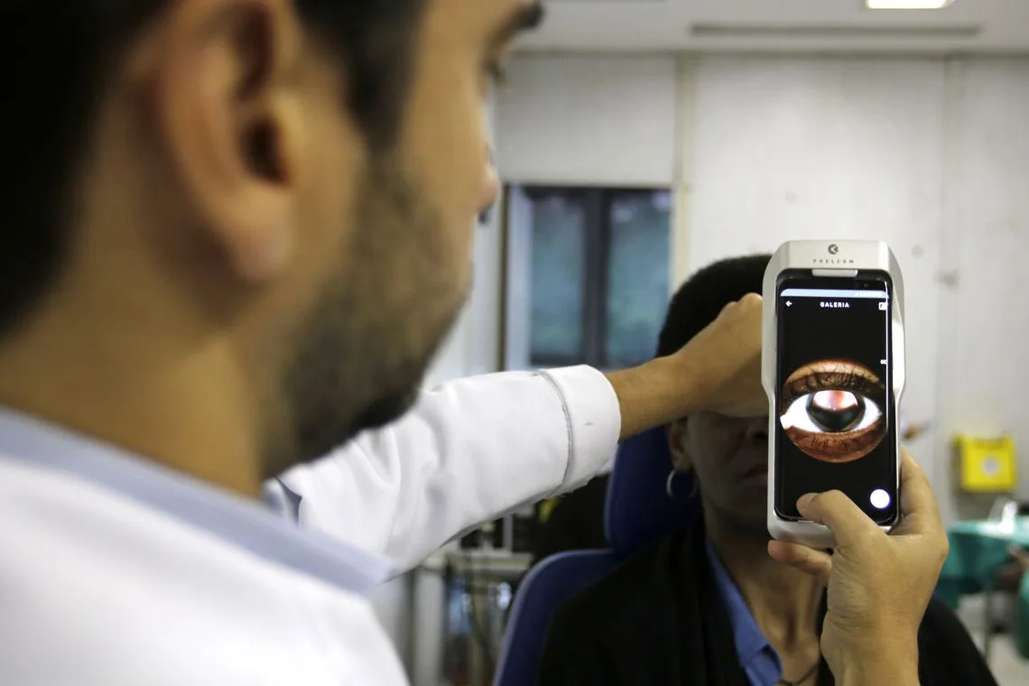 O Dr. Flávio Medina realiza exame de fundo de olho com um retinógrafo portátil,