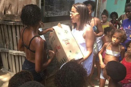 Anitta faz surpresa e presenteia moradores da Cidade de Deus com cestas básicas