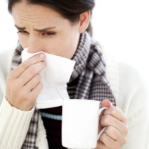 Woman Holding a Mug with a Handkerchief to Her Nose — Image by © Royalty-Free/Corbis