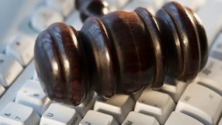 Judge’s gavel on computer keyboard — Image by © Tetra Images/Corbis