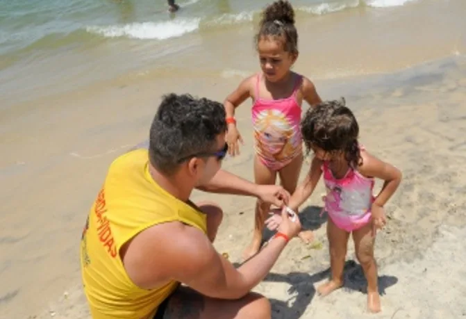 Guarda-vidas distribuem pulseiras de identificação para crianças nas praias de Vitória