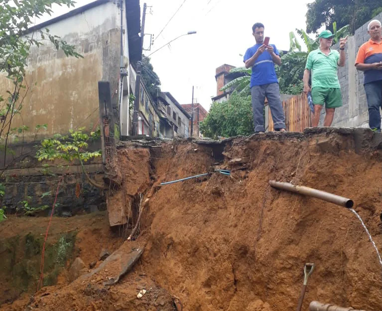 Vazamento de adutora faz rua ceder e provoca queda de muro em Cariacica