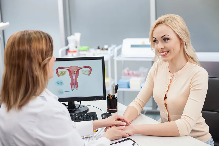 You have nothing to worry about. Cheerful female gynecologist is holding hand of young woman. The lady is looking at the doctor with trust and smiling