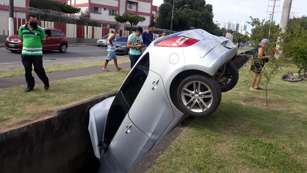 Criminosos roubam carro de motorista de aplicativo, são perseguidos pela polícia e acabam caindo dentro de valão