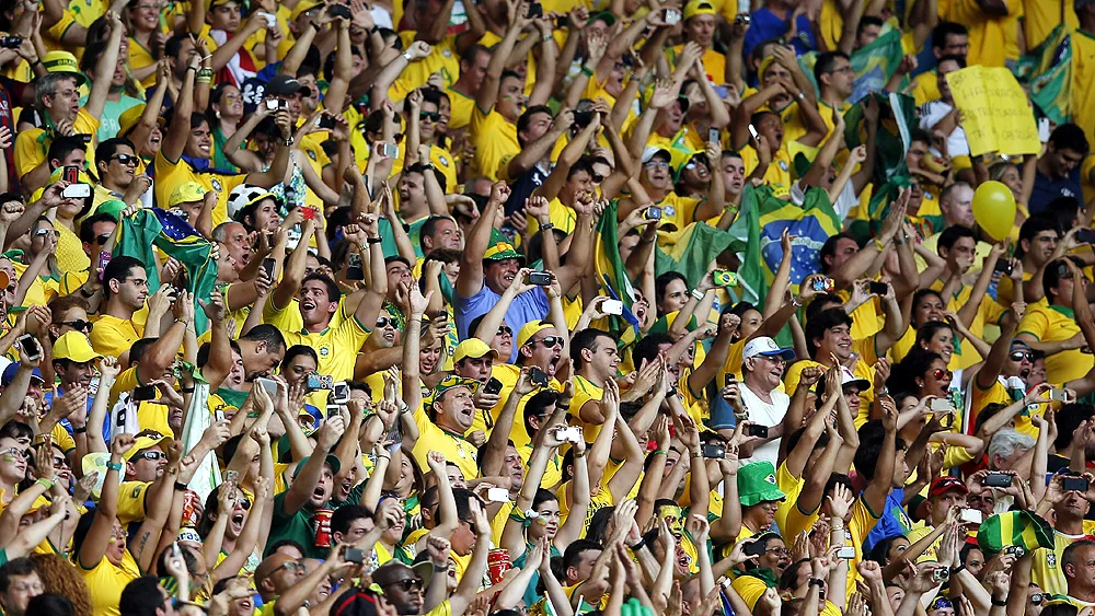 Brazilian fans cheer as their national team runs onto the pitch before the group A World Cup soccer match between Brazil and Mexico at the Arena Castelao in Fortaleza, Brazil, Tuesday, June 17, 2014. (AP Photo/Eduardo Verdugo)