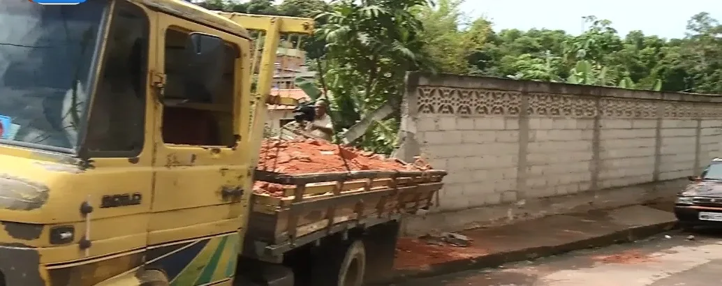 Sob efeito de álcool, motorista perde controle de caminhão, bate em carro e destrói muro de casa