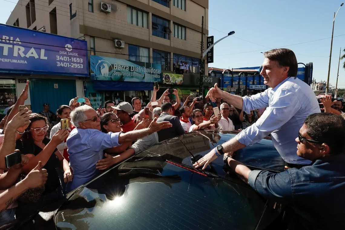 O presidente Jair Bolsonaro cumprimenta populares a caminho do evento de lançamento oficial do projeto Juntos pelo Araguaia, em Aragarças (GO).