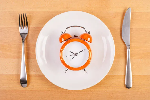 weight loss or diet concept. stock image of alarm clock on plate