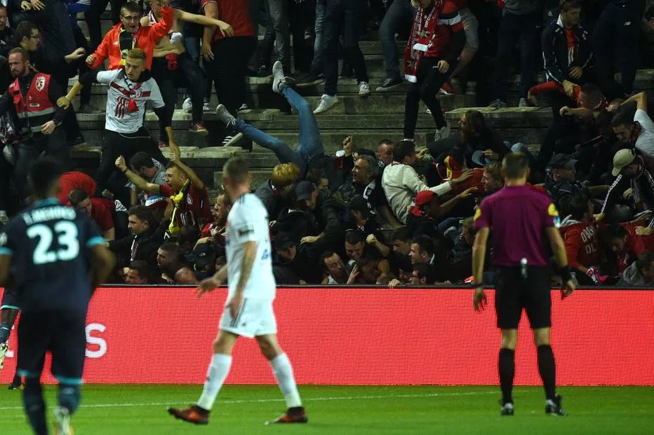 TOPSHOT – LOSC’s supporters react as their tribune falls down following the goal by LOSC’s Cameroonian midfielder Ibrahim Amadou during the French L1 football match between Amiens and Lille LOSC on September 30, 2017 at the Licorne stadium in Amiens. / AFP PHOTO / FRANCOIS LO PRESTI