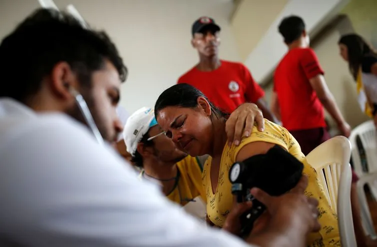 Uma mulher recebe atendimento médico depois que uma represa, de propriedade da mineradora brasileira Vale SA, explodiu em Brumadinho Uma mulher recebe atendimento médico depois que uma barragem, de propriedade da mineradora brasileira Vale SA, explodiu em Brumadinho, Brasil, em 26 de janeiro de 2019. REUTERS / Adriano Machado