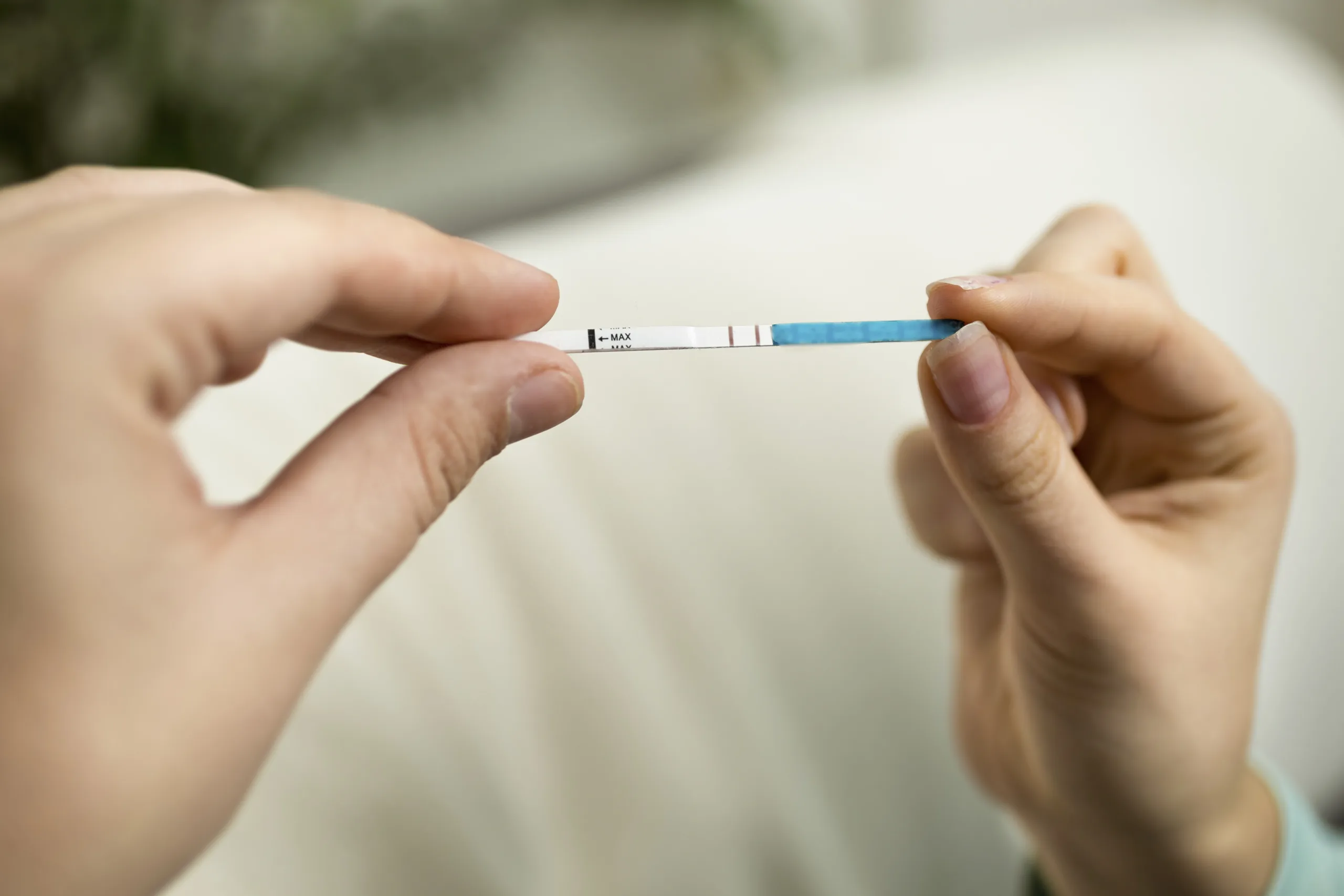 Closeup photo of woman holding positive pregnancy test