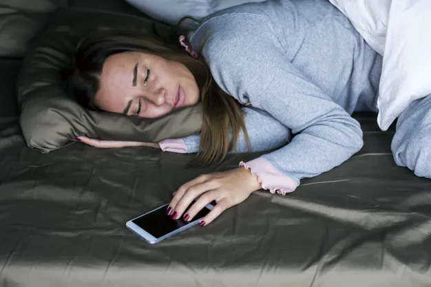 Young woman sleeping with mobile phone in bed. Working late at home.