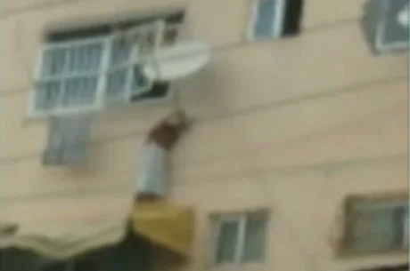 Imagens mostram criança pendurada em antena do lado de fora de apartamento