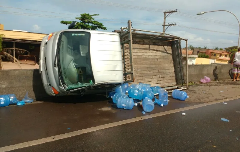 Caminhão carregado com galões de água capota na Rodovia do Sol e motorista fica ferido