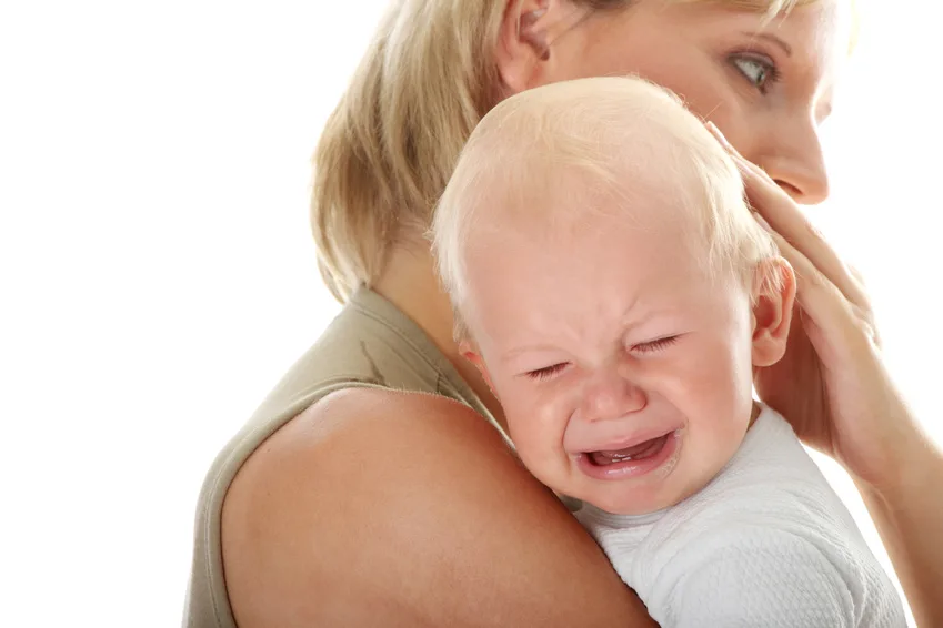 Mother holding her crying baby isolated on white background