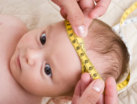 Arzt misst den Kopfumfang eines Babys