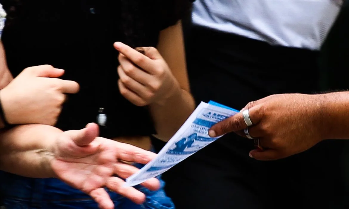 Trabalhador informal distribui panfleto na Avenida Paulista.