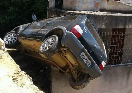 Carro fica pendurado em casa após motorista perder controle em ladeira, em Vila Velha