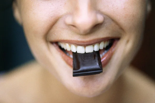 Young Woman Eating Chocolate — Image by © Roy Morsch/Corbis