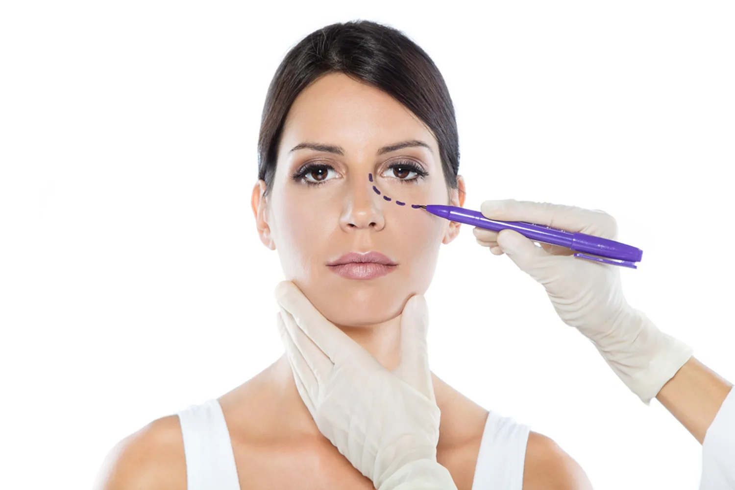 Portrait of plastic surgeon drawing dashed lines on her patient’s face.