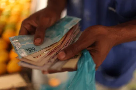 A street market vendor counts money in Rio de Janeiro, Brazil, Thursday, May 31, 2012. The real dropped for a third day falling 0.3 percent to 2.0224 per U.S. dollar. The currency has fallen 5.6 percent in May. Photographer: Dado Galdieri/Bloomberg via Getty Images