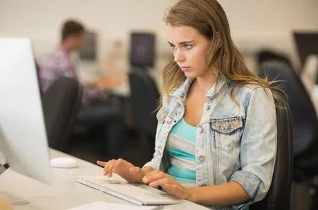 Focused young student working in the computer room