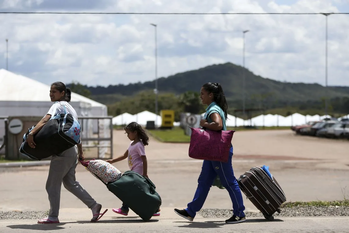 Imigrantes venezuelanos cruzam a fronteira com o Brasil.