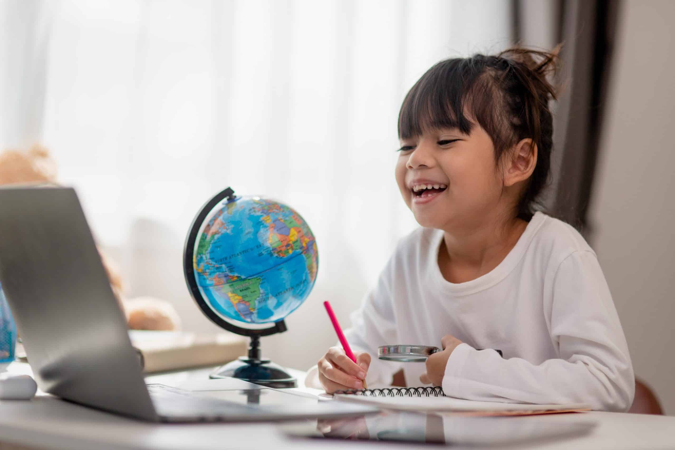 Asian little girl is learning the globe model, concept of save the world and learn through play activity for kid education at home.