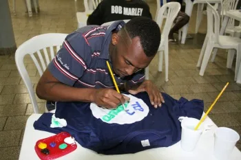 Moradores em situação de rua participando de projeto de pintura em tela