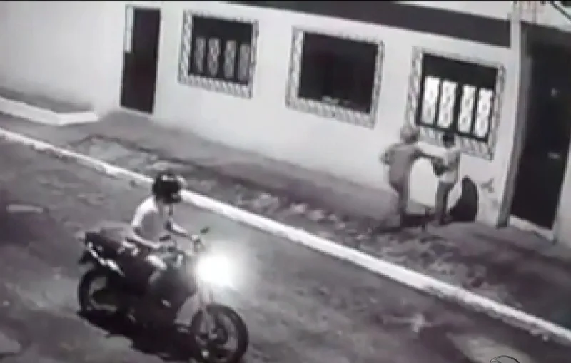 Operadora de caixa é rendida por homens de moto na porta de casa. Veja o vídeo!