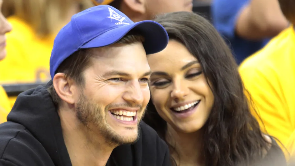 Ashton Kutcher and Mila Kunis sit in the stands as the Golden State Warriors face the Cleveland Cavaliers during Game Two of the 2016 NBA Finals on June 5, 2016 at ORACLE Arena in Oakland, California.