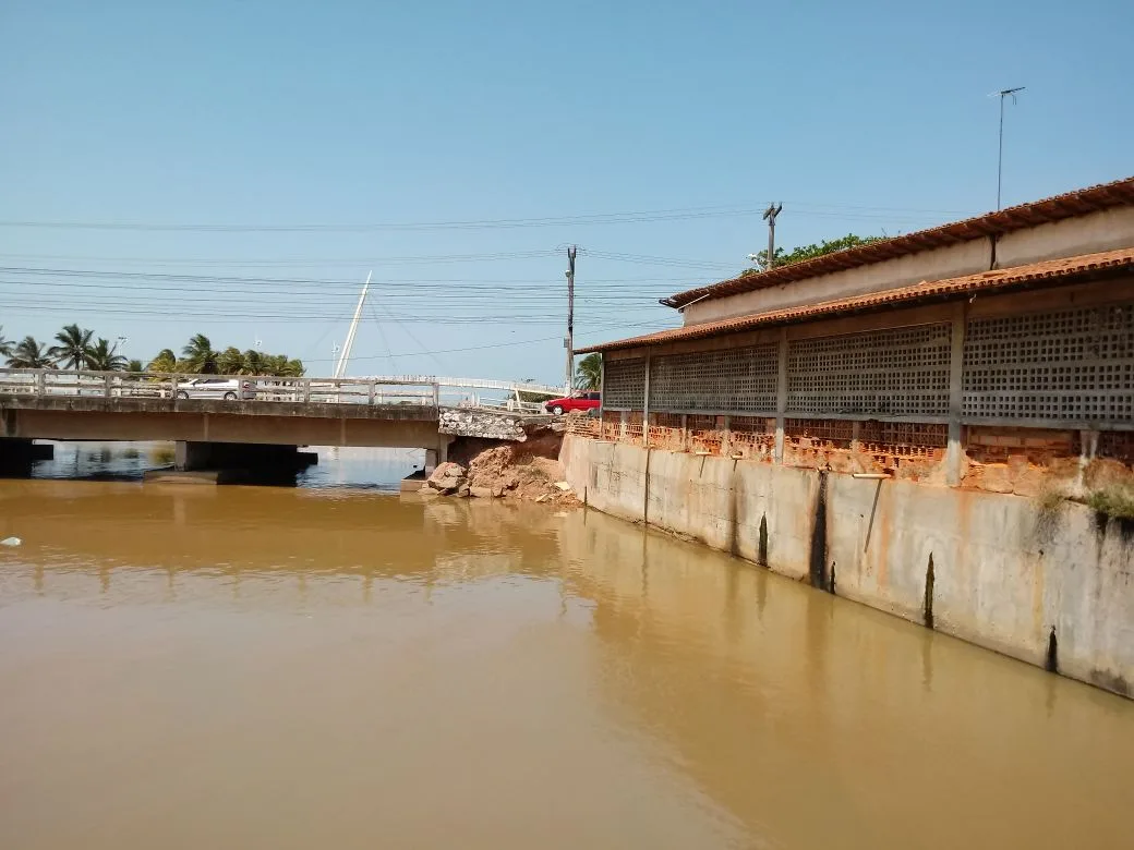 Imagem mostra ponte sem mureta e terra cedida em Jacaraípe, na Serra