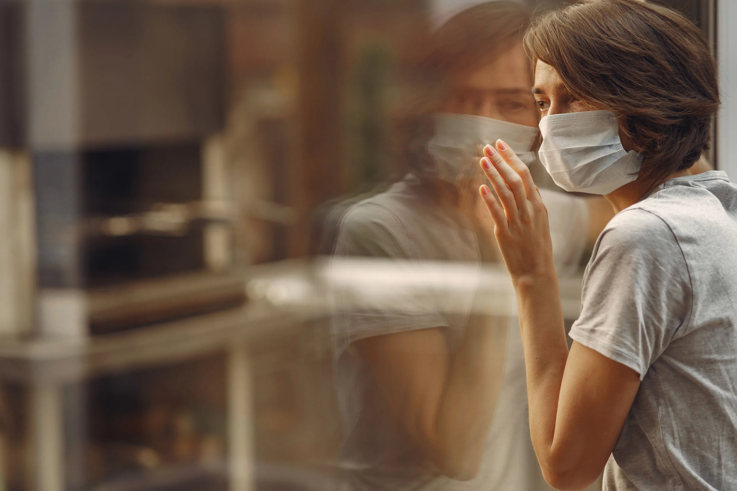 Woman in mask. Coronavirus theme. Lady by the window.