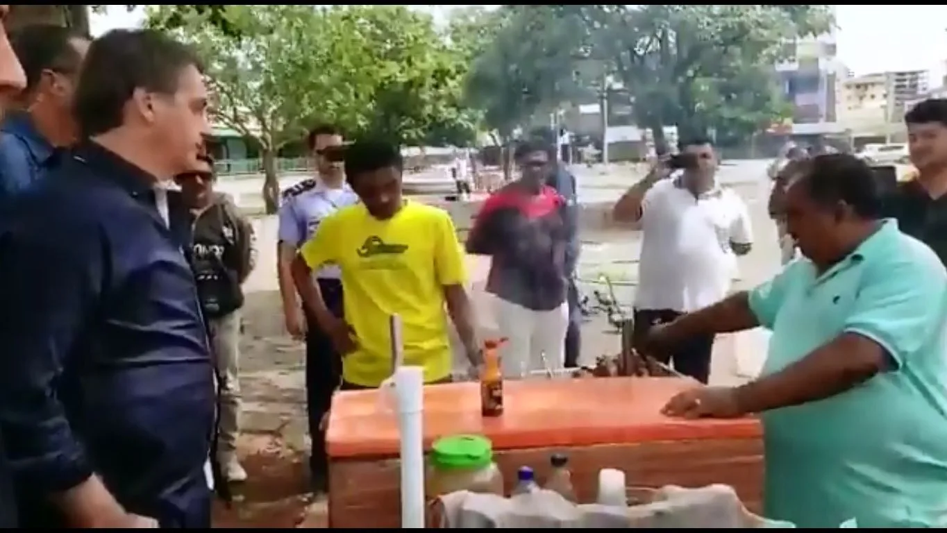 Bolsonaro conversando com comerciante neste domingo, 29