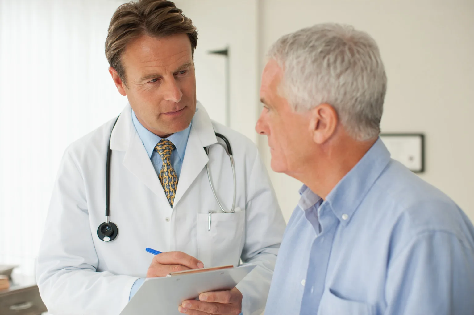 Doctor talking with patient in doctorÂ?s office