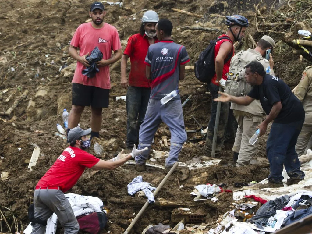 Bombeiros, moradores e voluntários trabalham no local do deslizamento no Morro da Oficina, após a chuva que castigou Petrópolis, na região serrana fluminense