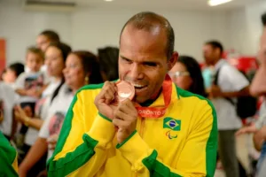 Daniel Mendes exibe e morde a medalha de bronze que conquistou no Parapan de Toronto (Foto: Wilbert Suave)