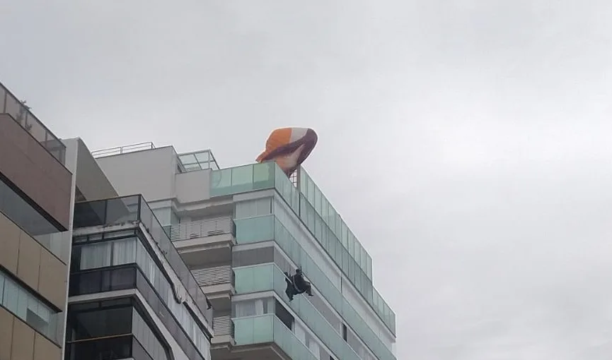 VÍDEO | Piloto de parapente fica preso em cobertura de prédio na Praia da Costa