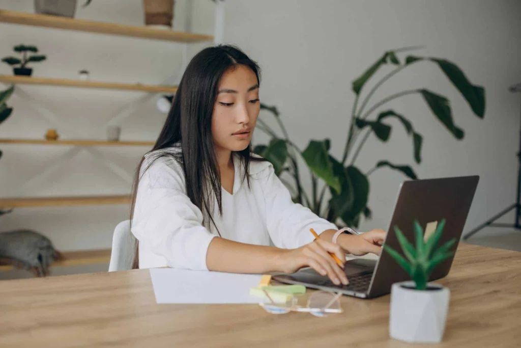 Woman working on computer at the desk from home