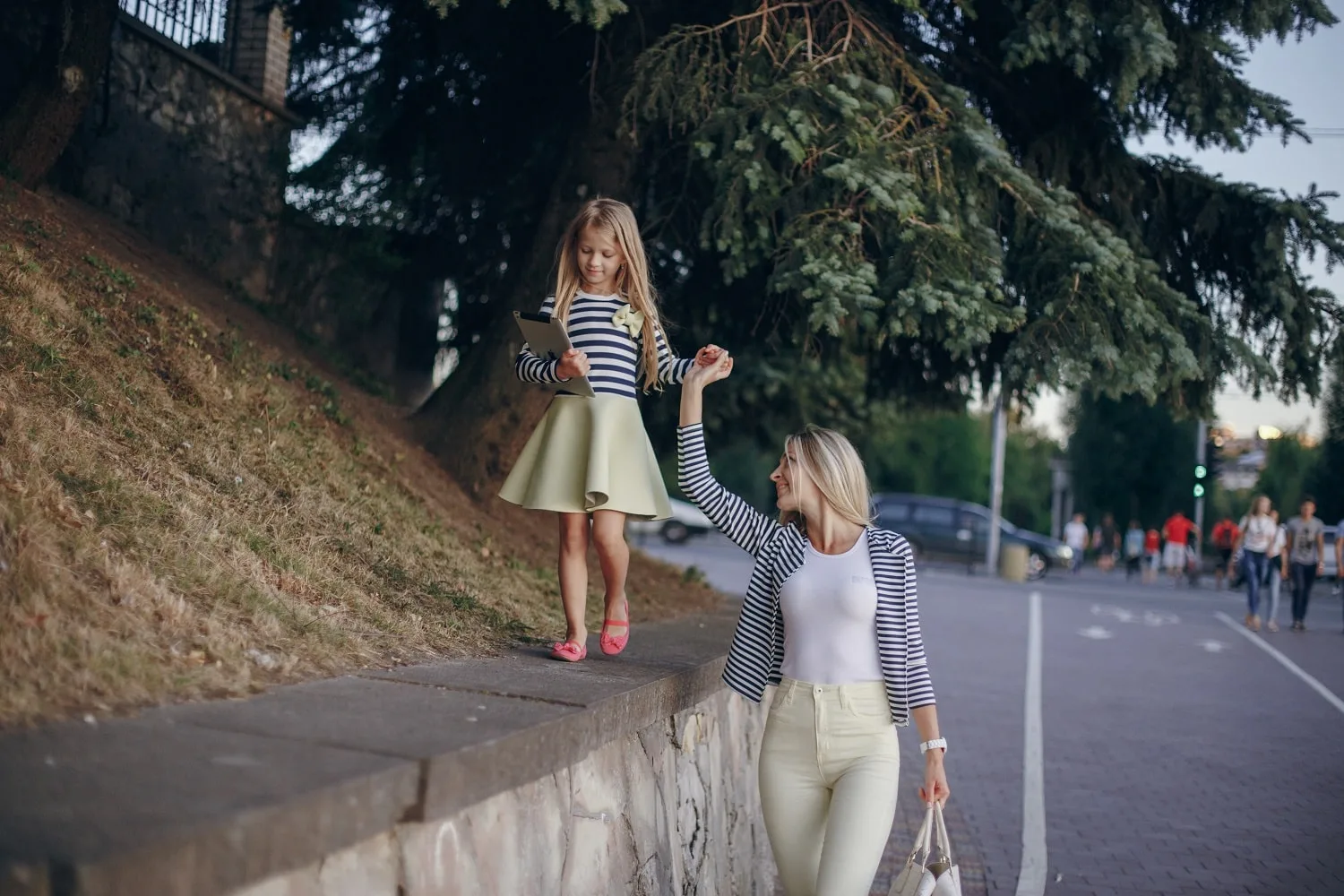 Mãe e filha passeando em cidade