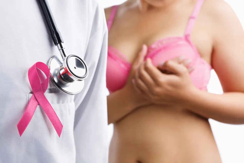 Doctor with pink badge and woman on pink bra on background, a aconcept for breast cancer