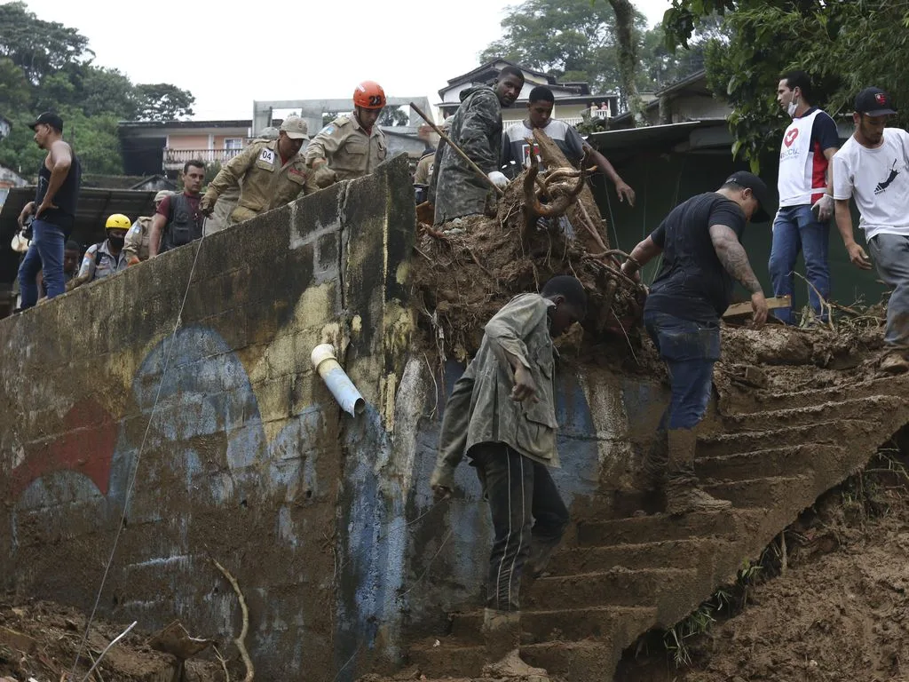 Bombeiros, moradores e voluntários trabalham no local do deslizamento no Morro da Oficina, após a chuva que castigou Petrópolis, na região serrana fluminense